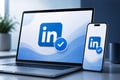 Laptop and smartphone displaying the LinkedIn logo and verification badge on a modern blue-and-white digital background.