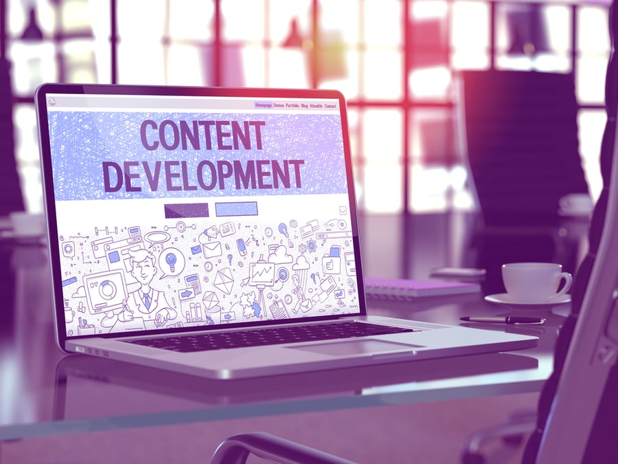 Workplace with Laptop showing Landing Page with text Content Development.