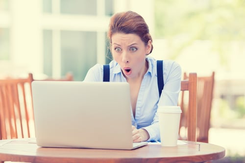Young business woman using laptop looking at computer screen face looks excited.