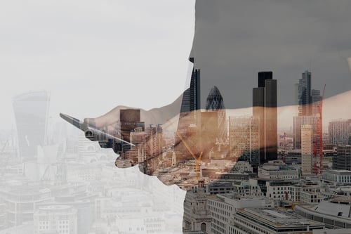 Person holding iPhone - city buildings in the background