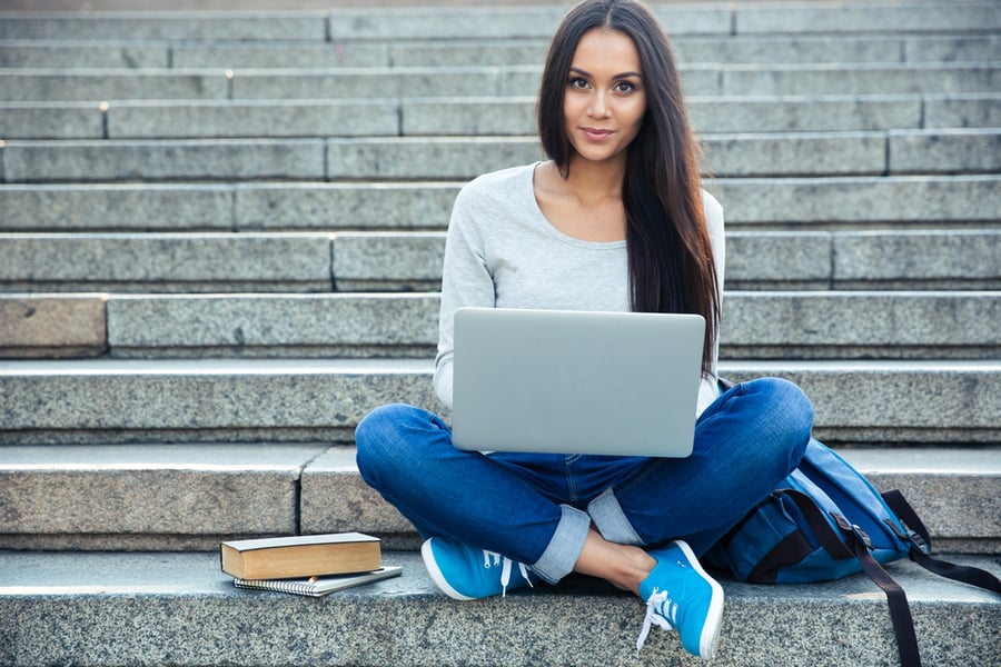 Girl sitting on steps with Laptop in her lap
