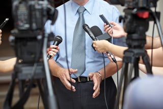 close up of conference meeting microphones and businessman.jpeg