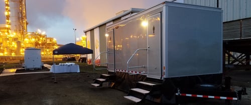 raised, silver trailer in parking lot with steps leading to the doors