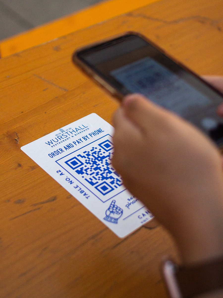 adWhite Resurgence of QR Codes and Why This Matters for your Marketing Image of Phone Scanning QR Code on Restaurant Table