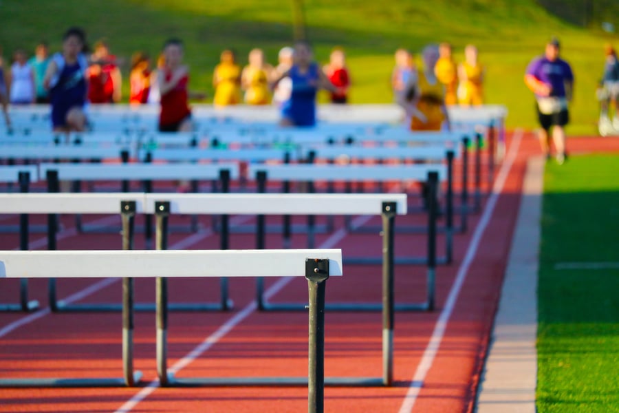 high school track with hurdles and runners