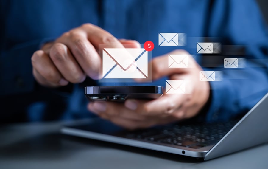 Email notification on phone next to laptop
