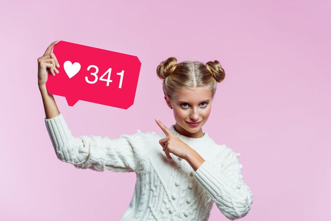 girl holding sign with 341 "likes"