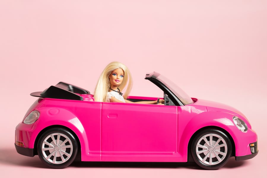 barbie doll in a pink car
